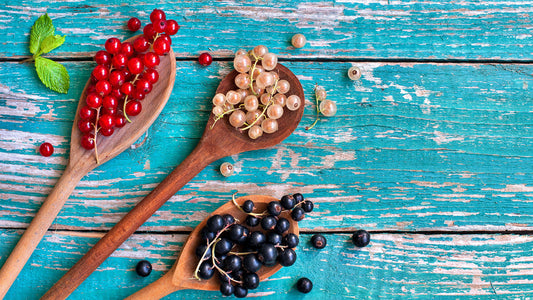 Varietà di ribes su cucchiai di legno