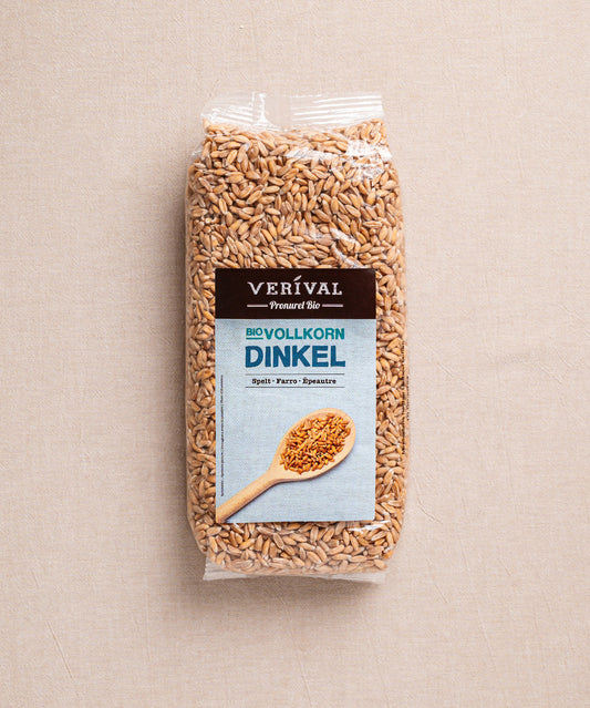 Die Bio-Vollkorn-Dinkelpackung von Verival Bio zeigt Dinkelkörner auf einem Holzlöffel, perfekt zum Backen mit einem herrlich nussigen Aroma.