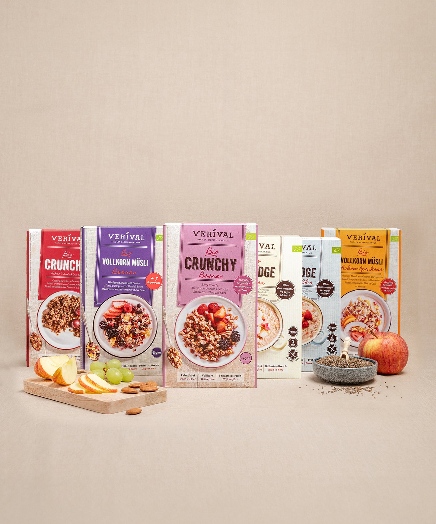 Das Bestseller-Vorteilspack enthält sechs Frühstücksproukte der Verival Bio GmbH. Diese präsentieren sich neben einem Holzbrett mit Apfelscheiben, Weintrauben und einem Apfel mit Kernen.