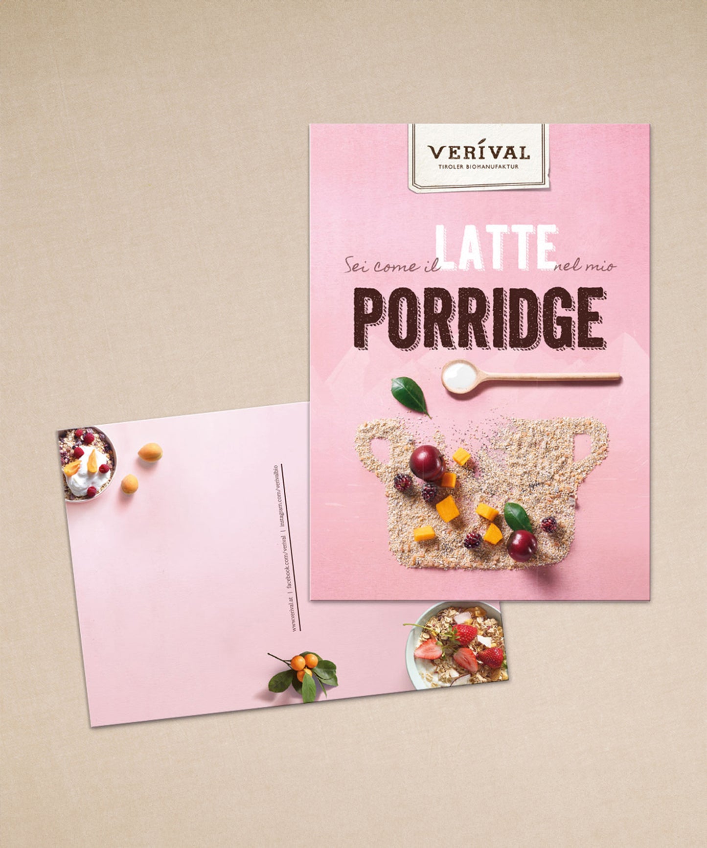 Zwei rosa Verival-Postkarten liegen auf einer beigen Oberfläche. Eine zeigt die Zutaten, die andere eine Löffelgrafik, italienischen Text und Körner in Topfform – ideal, um einzigartige Geschenksets zu ergänzen.